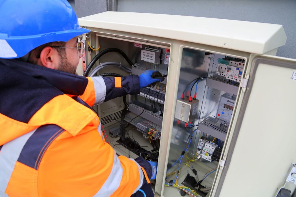 Electricista con casco revisando un cuadro eléctrico